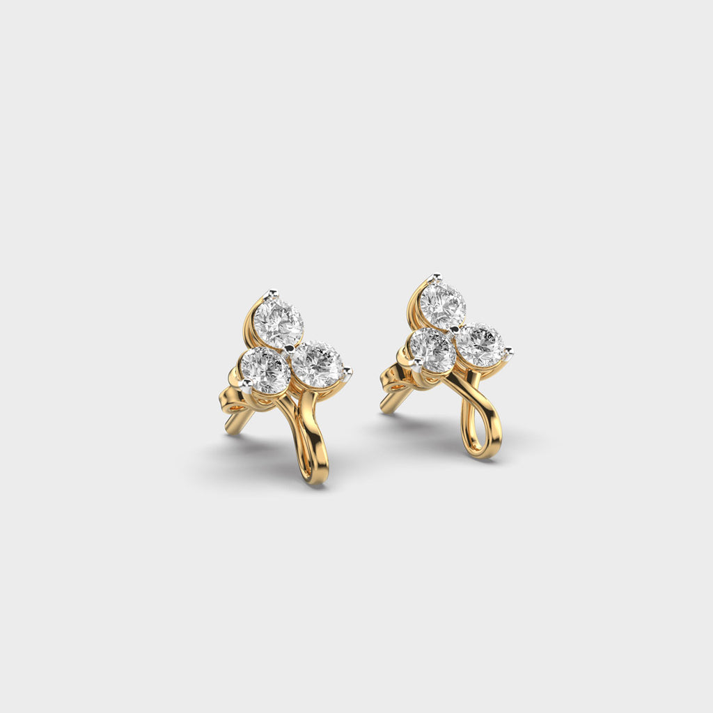 Yellow gold diamond earrings photographed from a top-side angle, emphasizing the organic twisted stem.