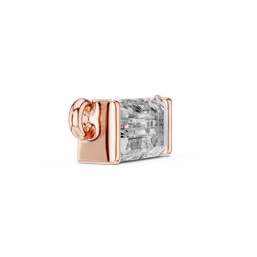 Rose gold charm with a clear gemstone on a white background