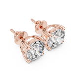 Rose gold round solitaire diamond stud earrings photographed from the top, highlighting symmetrical prong placement and diamond sparkle