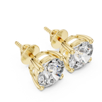 Yellow gold round diamond stud earrings captured at a front angle, featuring classic four-prong solitaire design with high brilliance diamonds