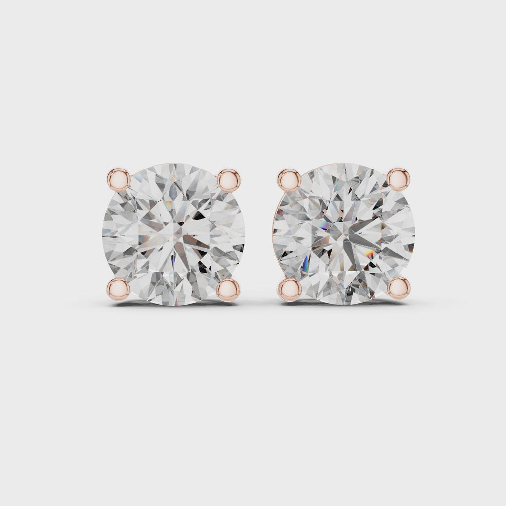360 degree rotating video of rose gold round diamond stud earrings showcasing full basket setting, prongs, and diamond brilliance from every angle