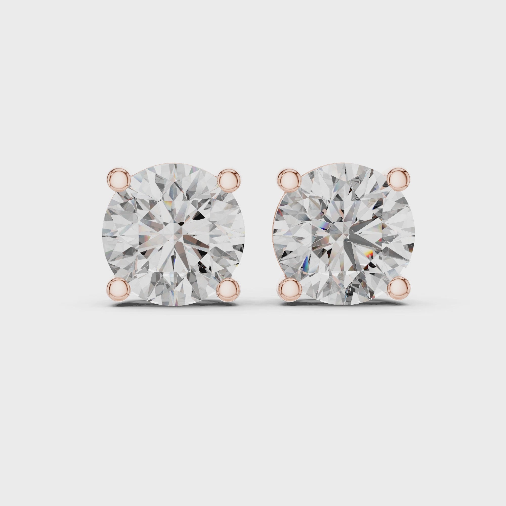 360 degree rotating video of rose gold round diamond stud earrings showcasing full basket setting, prongs, and diamond brilliance from every angle